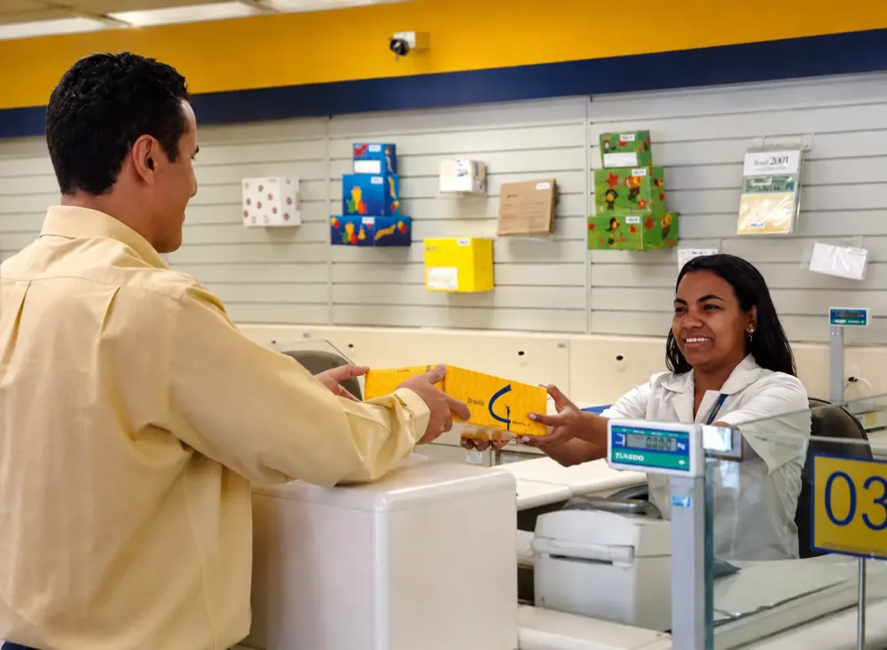 Atendente comercial recebe uma encomenda de um cliente em estabelecimento de Registro. Imagem ilustrativa aprimorada com inteligência artificial a partir da foto fornecida.