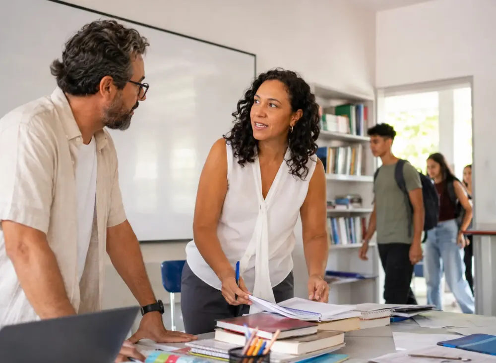  Professores preparam materiais para aulas do Ensino Médio enquanto estudantes entram na sala. Imagem ilustrativa gerada por inteligência artificial/OpenAI.
